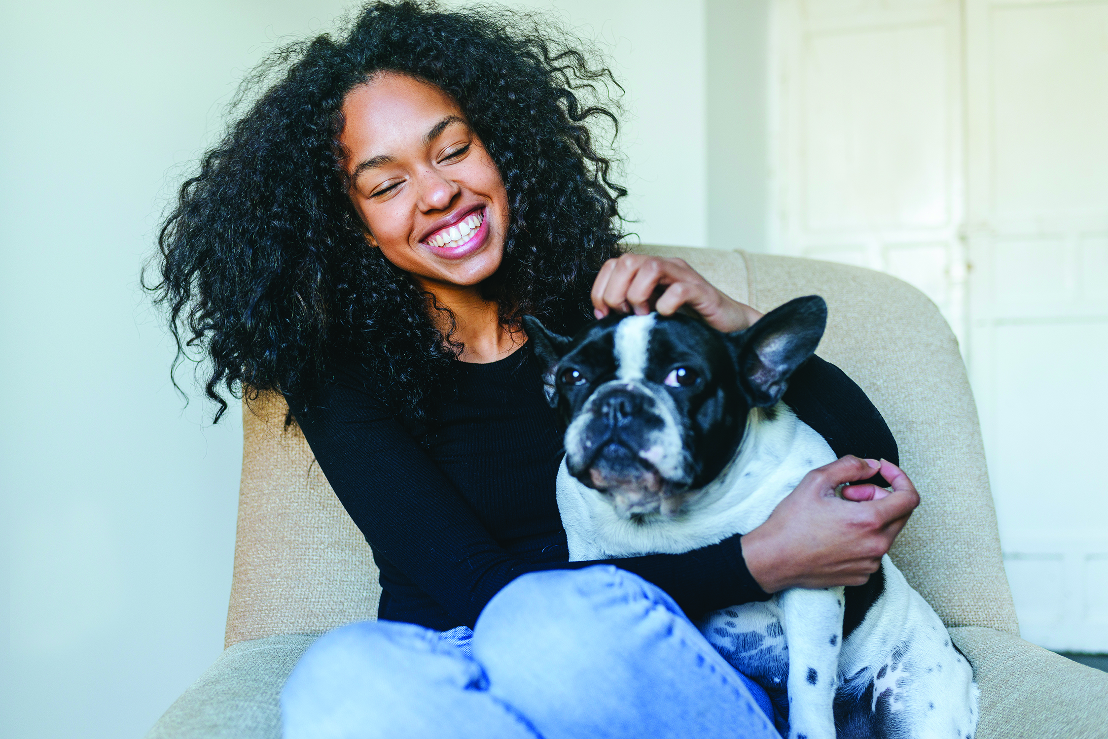 Young woman sitting next to her dog Family Features
