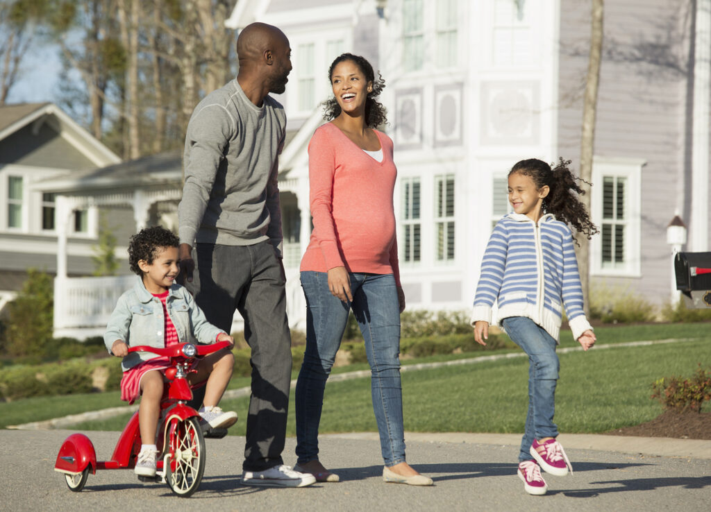 Family walking together on suburban street Family Features