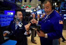 Stocks edge lower as dollar rises to one-year high